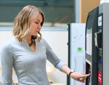 serunion-vending-maquina-mujer-pulsando-servicio serunion-vending-maquina-mujer-pulsando-servicio