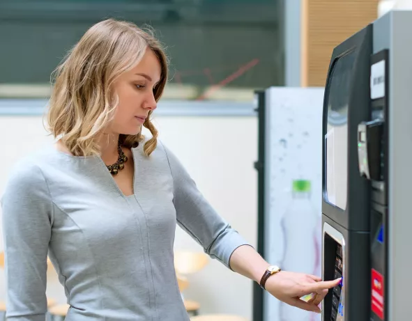 serunion-vending-maquina-mujer-pulsando-servicio